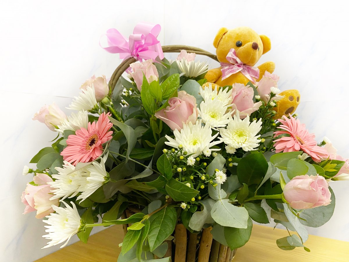 A basket of flowers for mom and a teddy for your little girl!